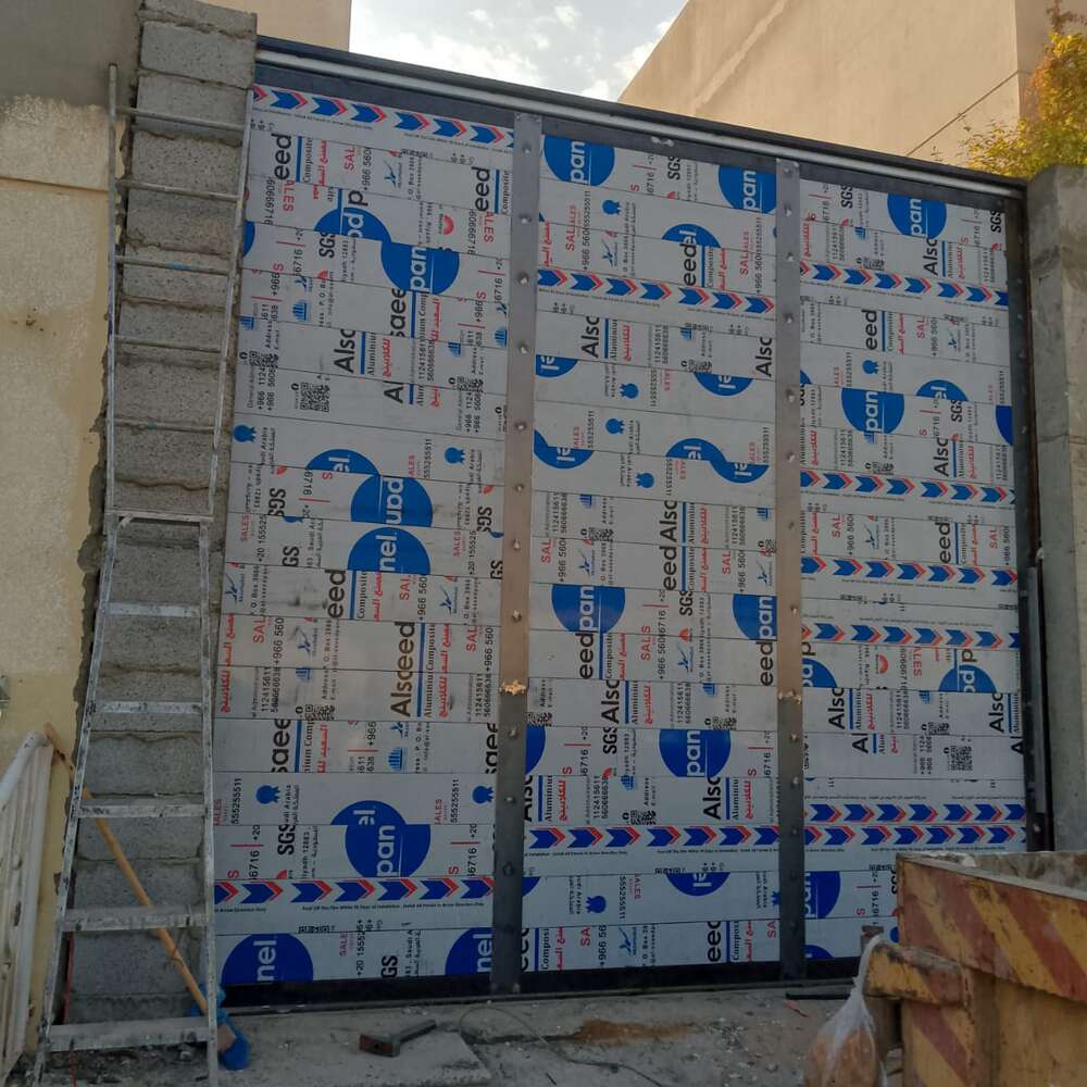 بوابة حديد كبيرة أثناء التركيب مغطاة بألومنيوم كومبوزيت